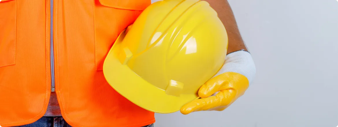 A construction worker holding a safety helmets